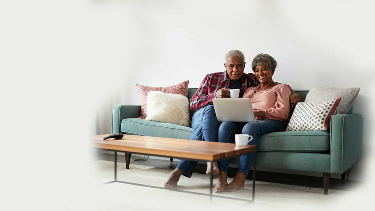 Happy couple looking at their laptop while using the client portal